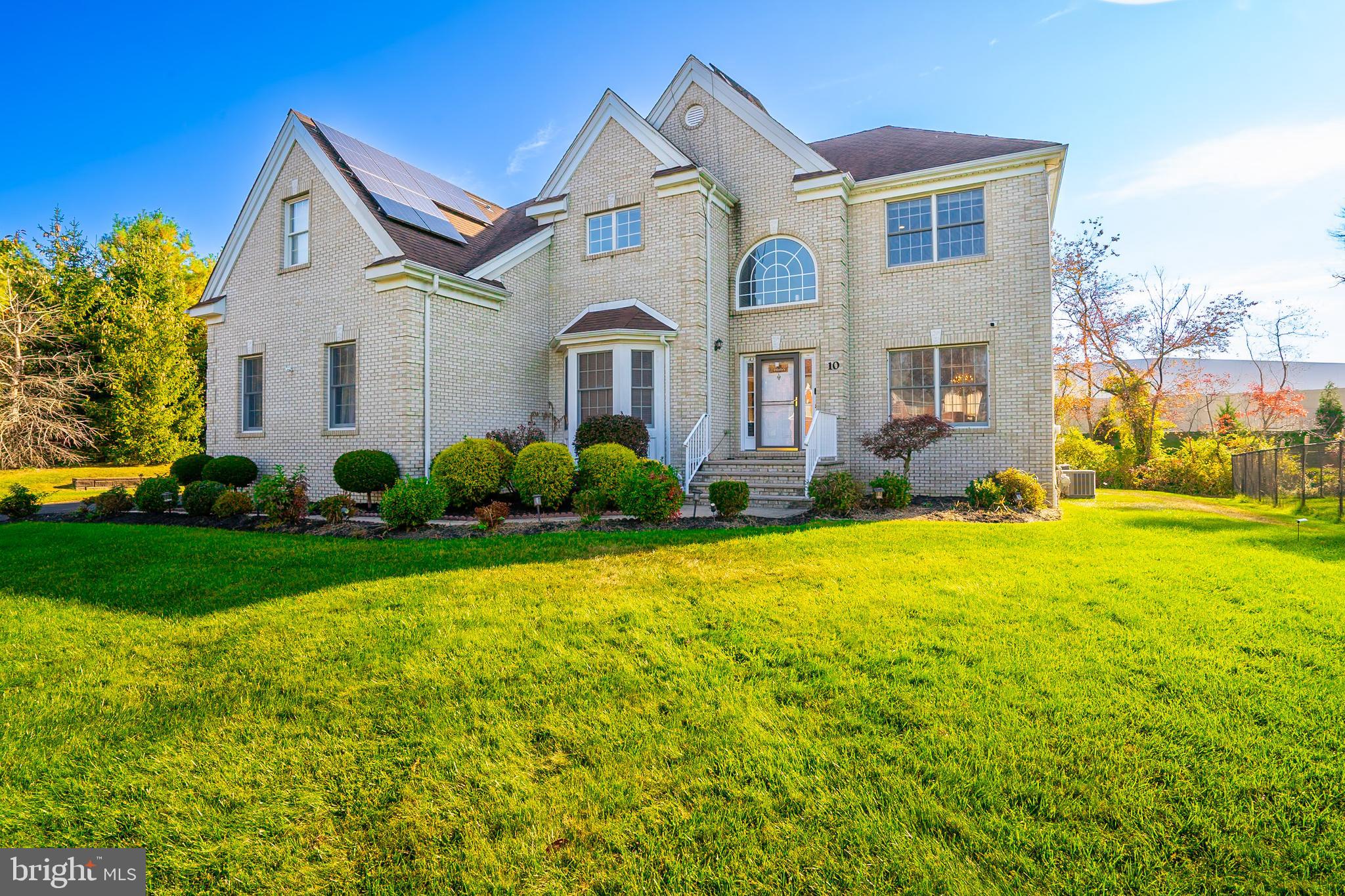 a front view of a house with a yard and trees