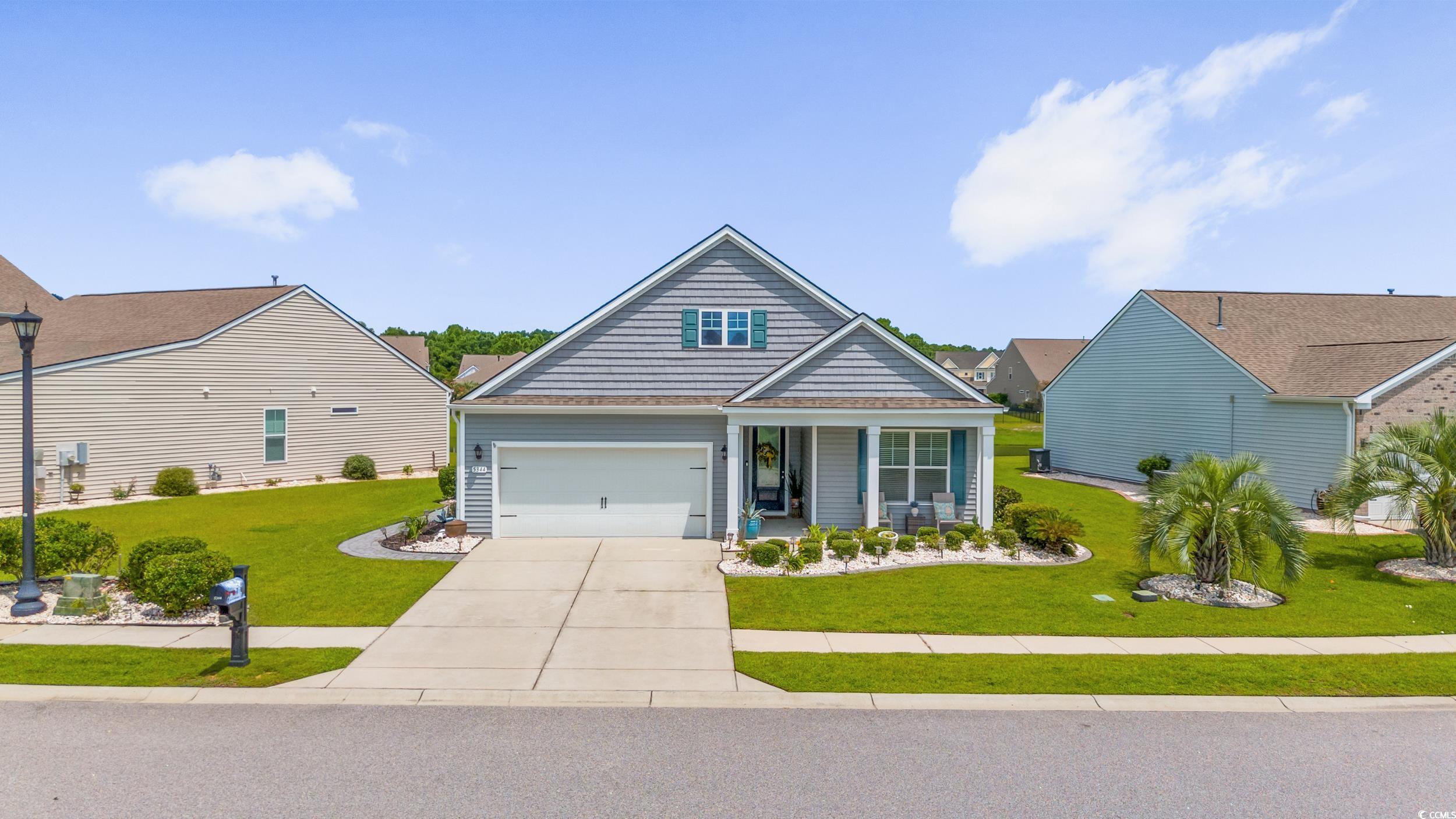 View of front of home with a garage and a front ya