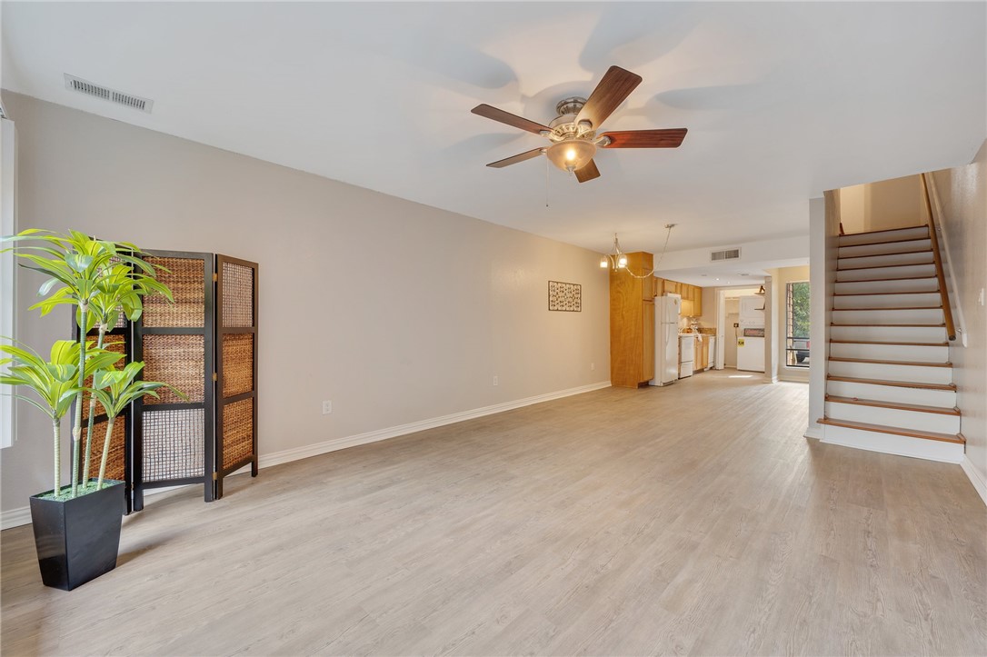 Living room with chandelier and light hardwood / w