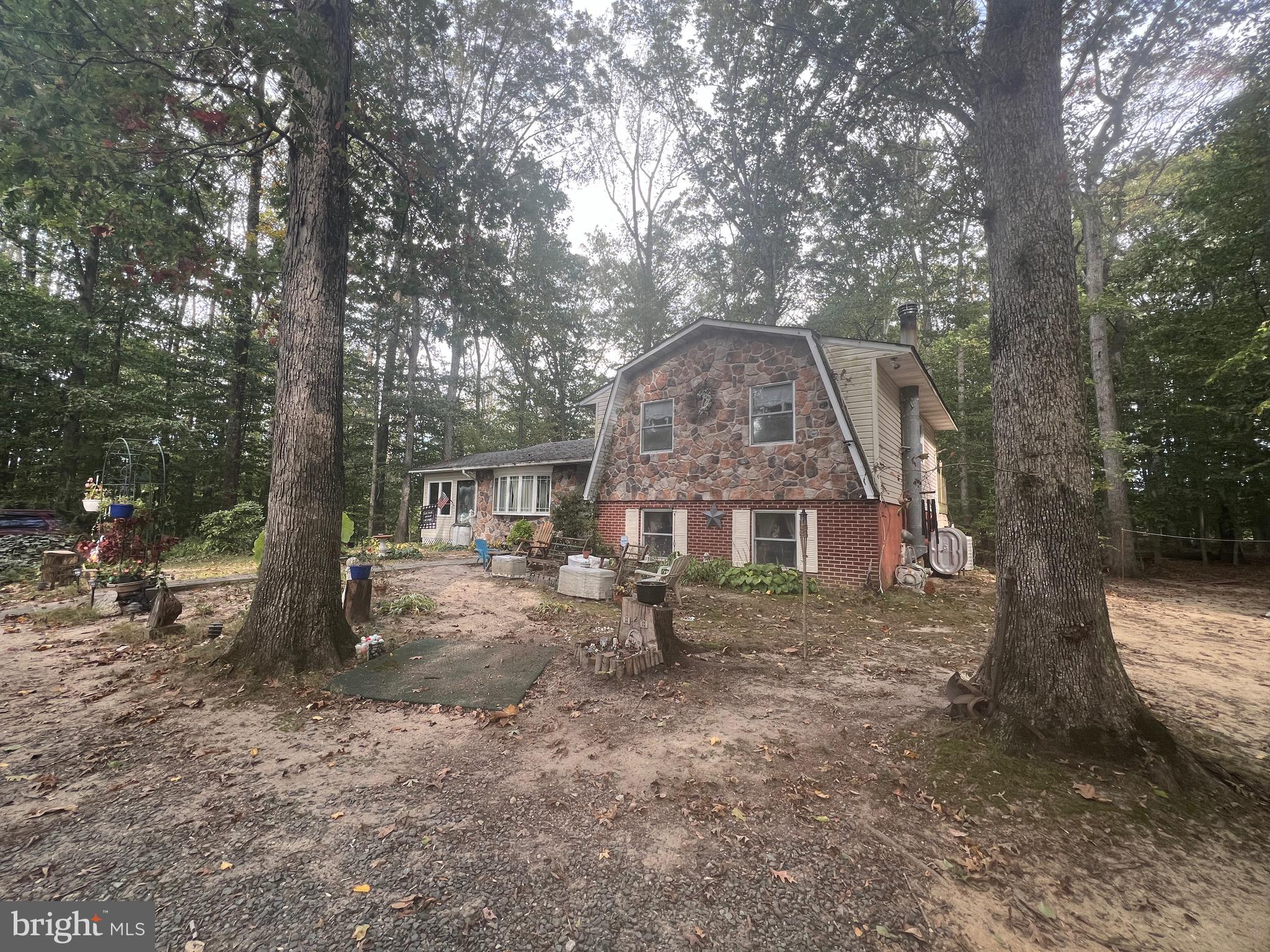 a view of a house with a yard and large trees