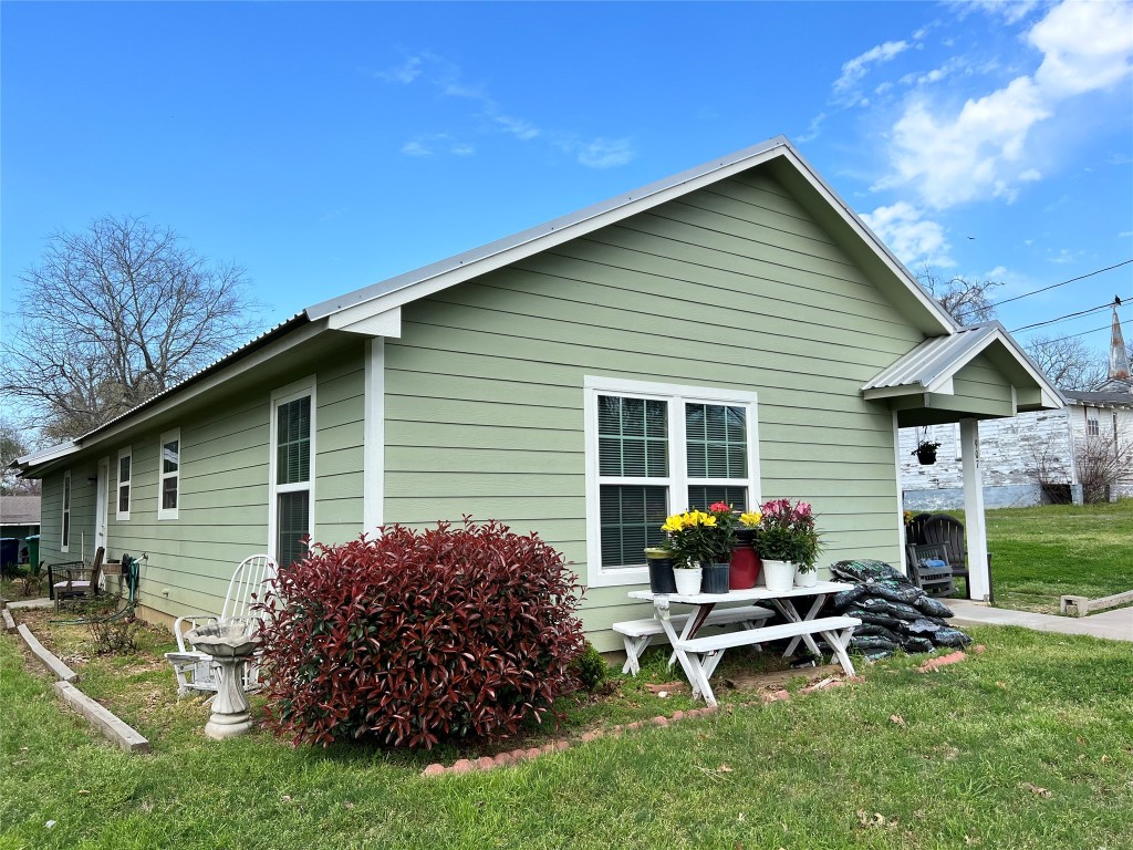 a view of a house with backyard and chairs