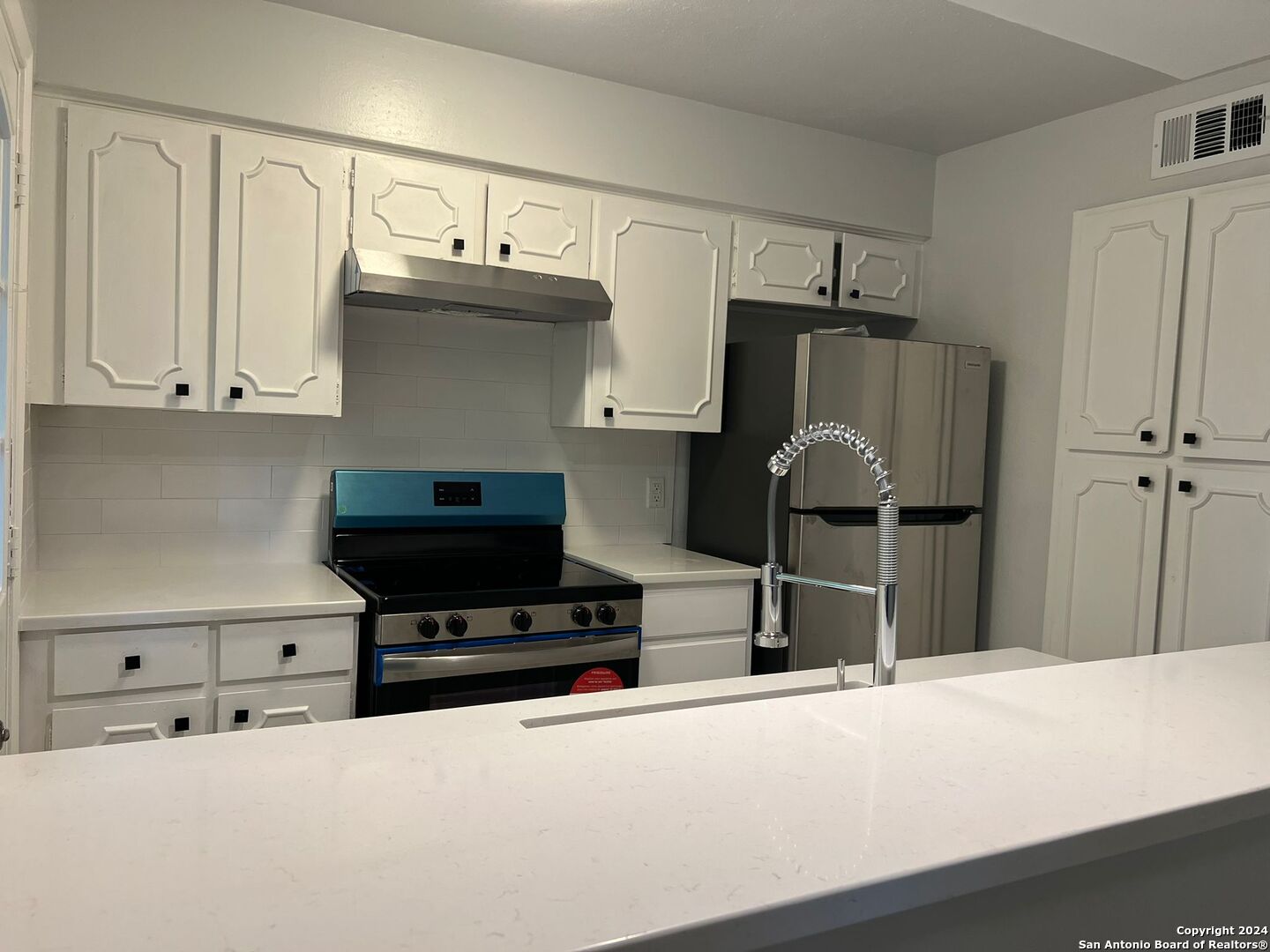 a kitchen with stainless steel appliances a stove and a refrigerator