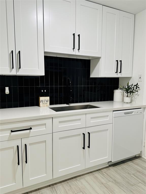 a kitchen with white cabinets and sink