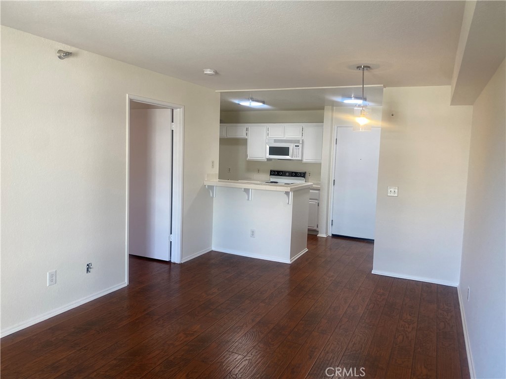 a view of a kitchen with a sink wooden floor and a refrigerator