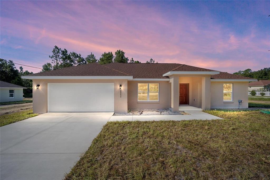 a front view of a house with a yard and garage