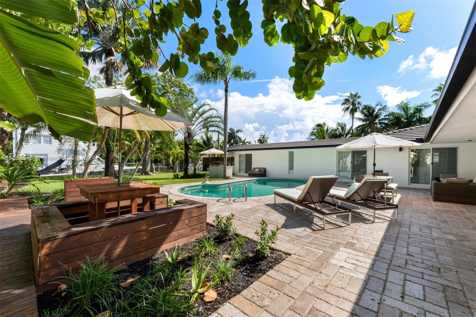 a backyard of a house with barbeque oven table and chairs