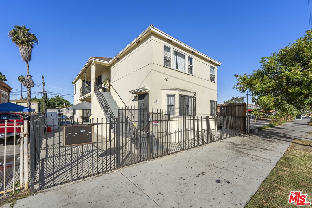 a front view of a house with iron fence