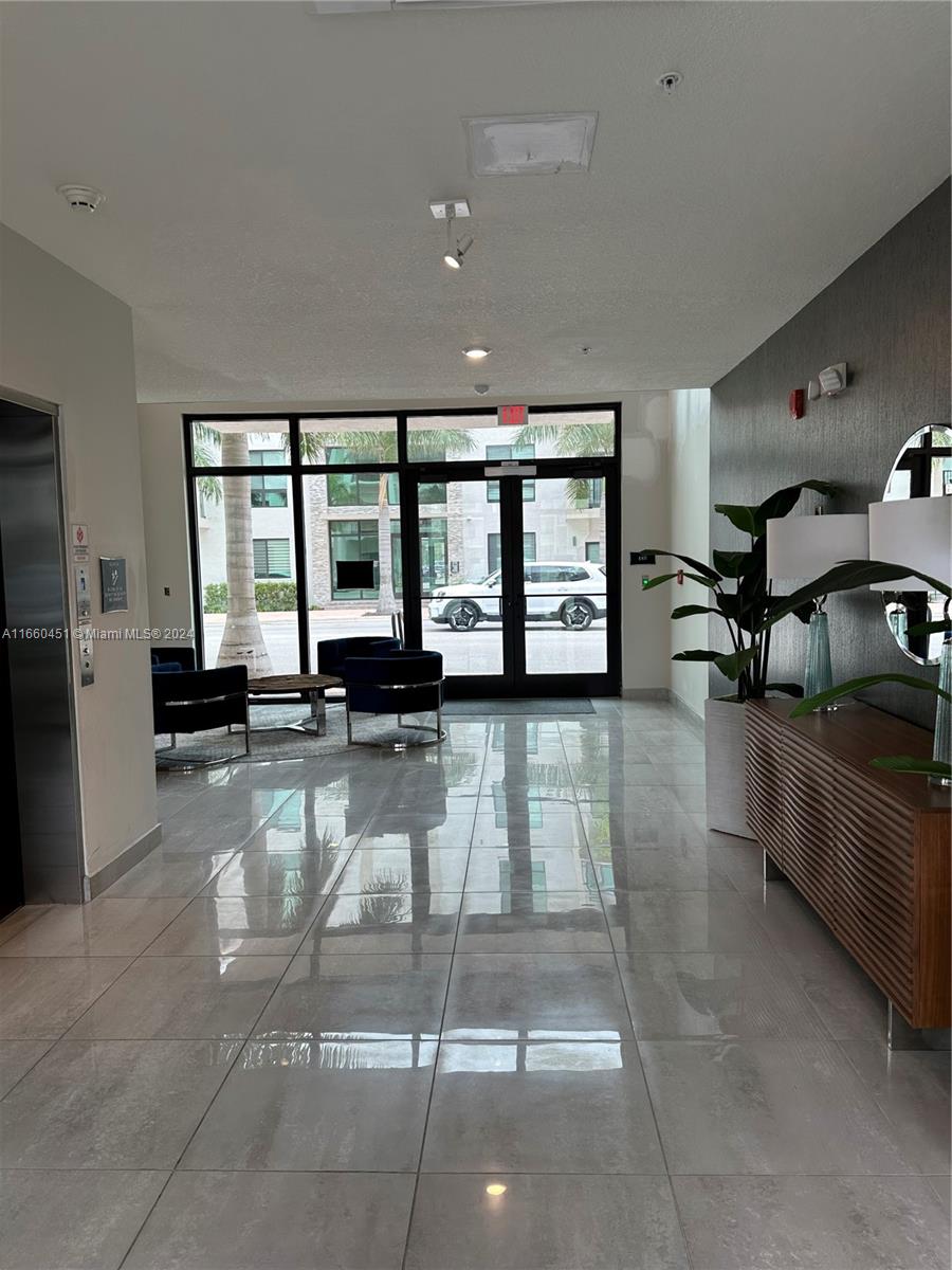 a lobby with furniture and large windows