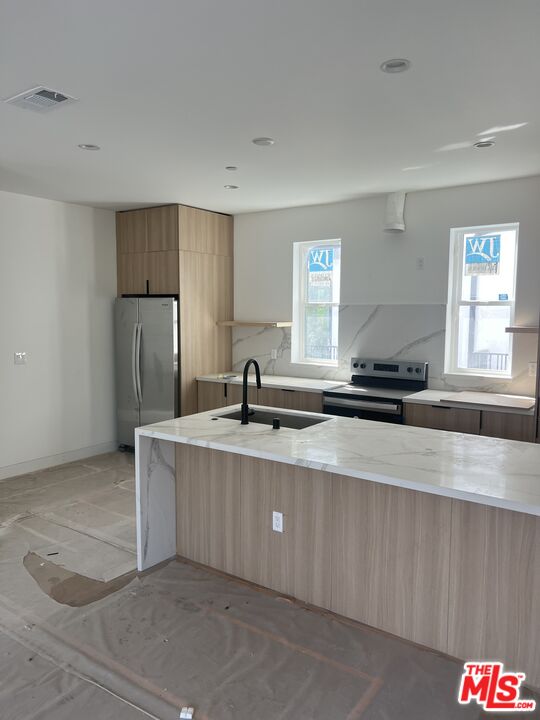 a large kitchen with a refrigerator a sink and dishwasher