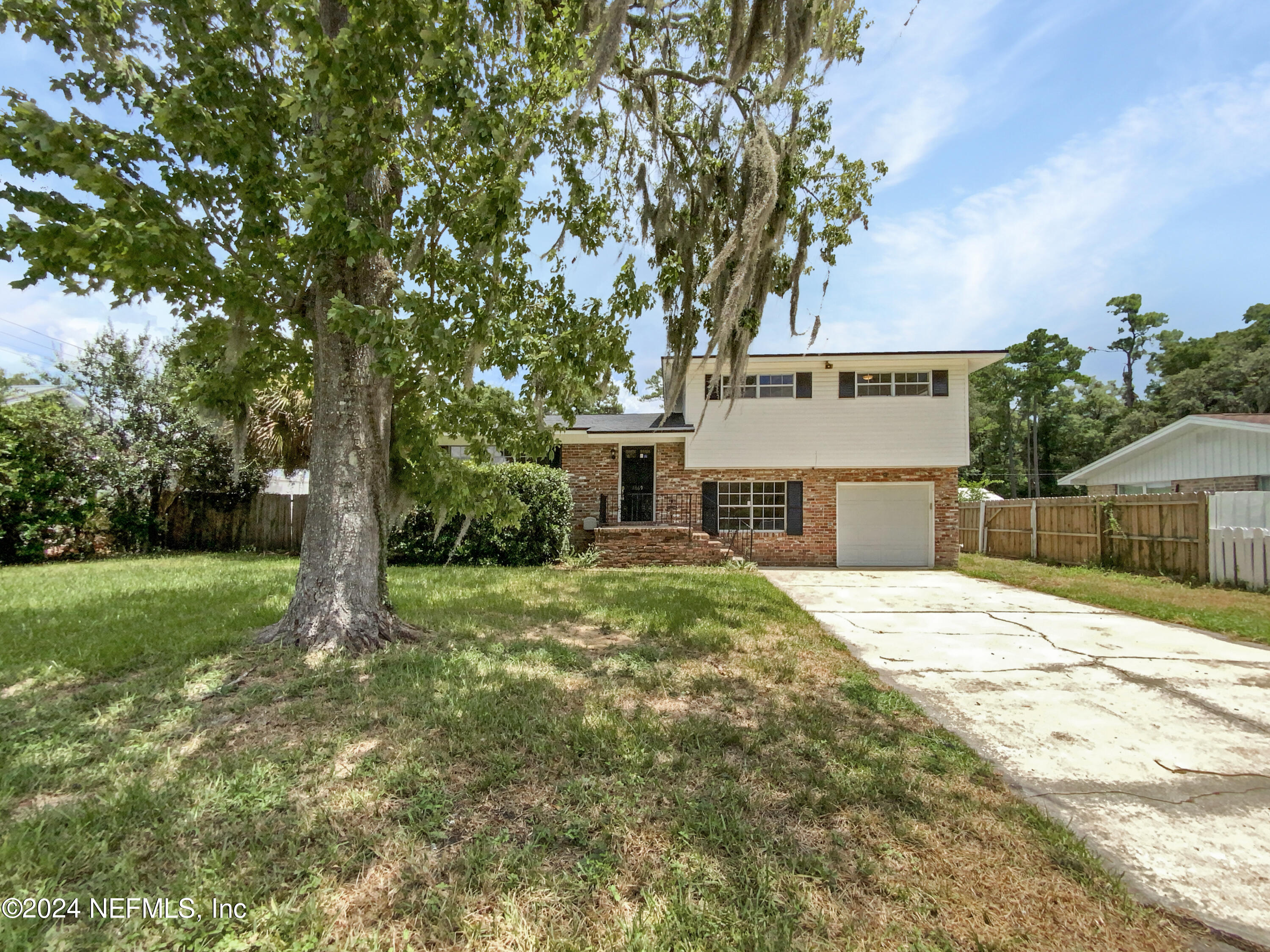 a front view of a house with a garden and trees