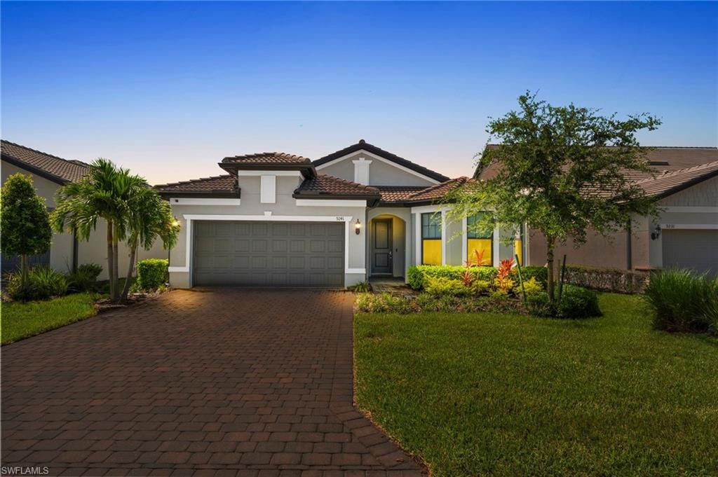 a front view of a house with a yard and garage