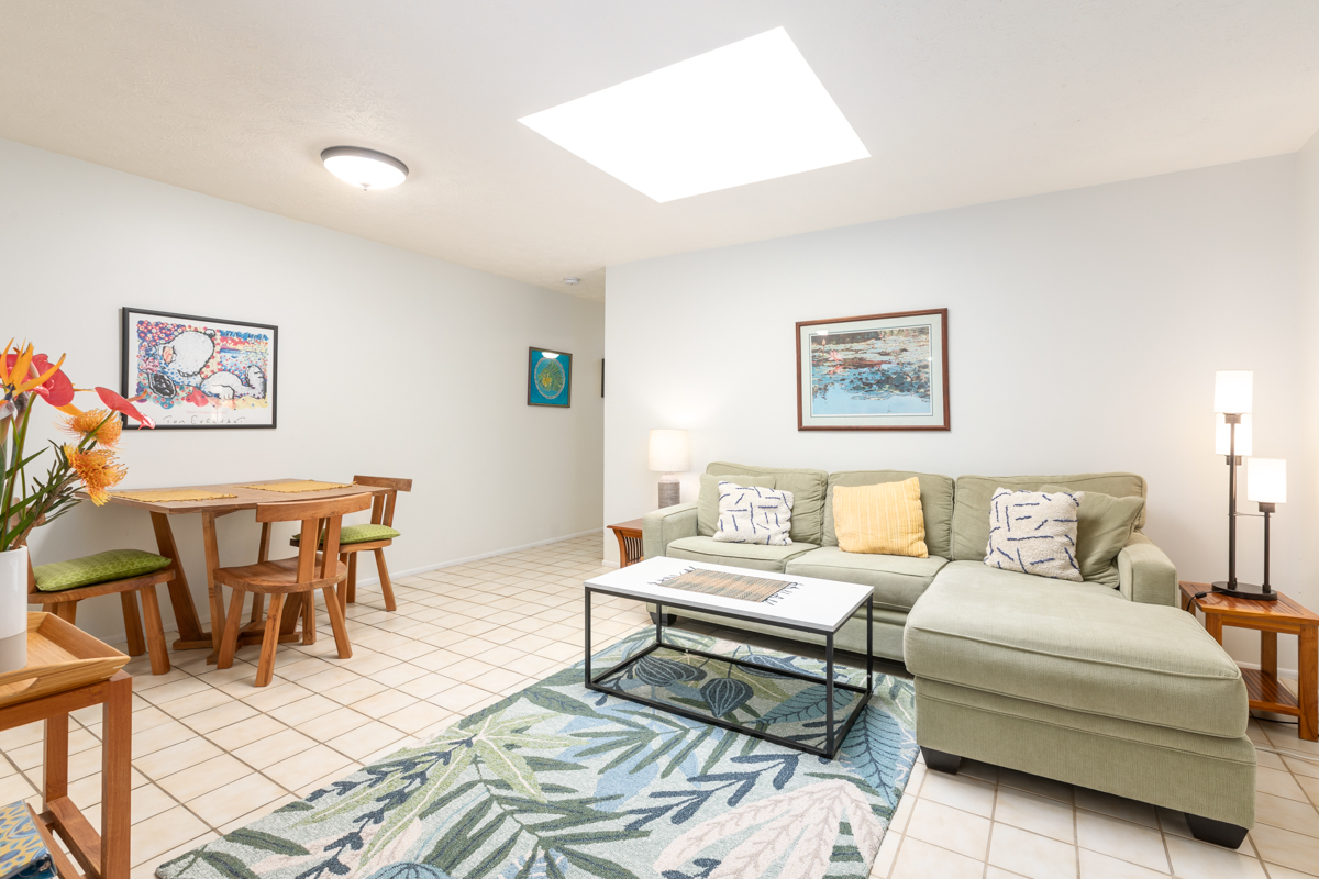 a living room with furniture a rug and a lamp