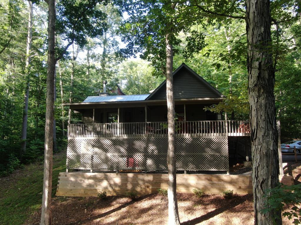 a view of a small yard in front of a house with large trees and plants