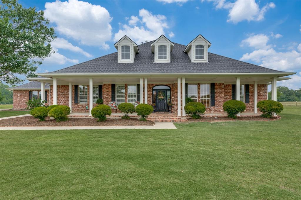 a front view of a house with garden and porch