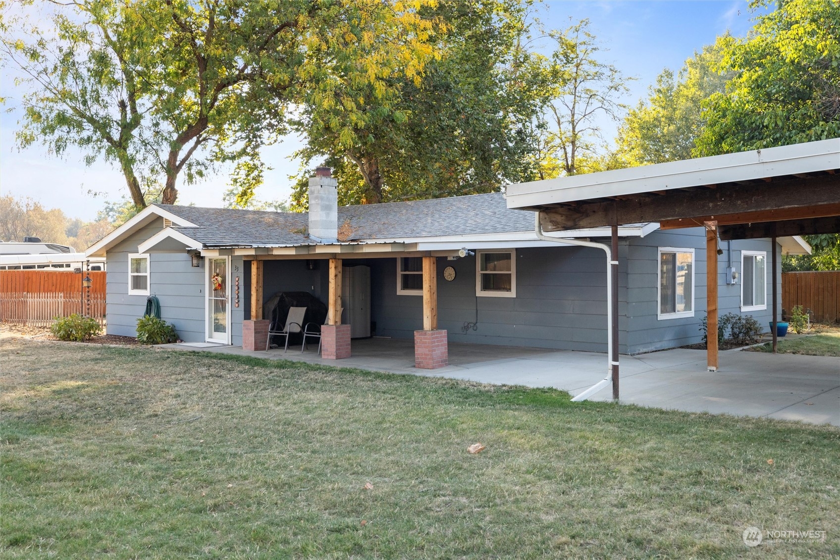 a view of a house with a yard and large tree