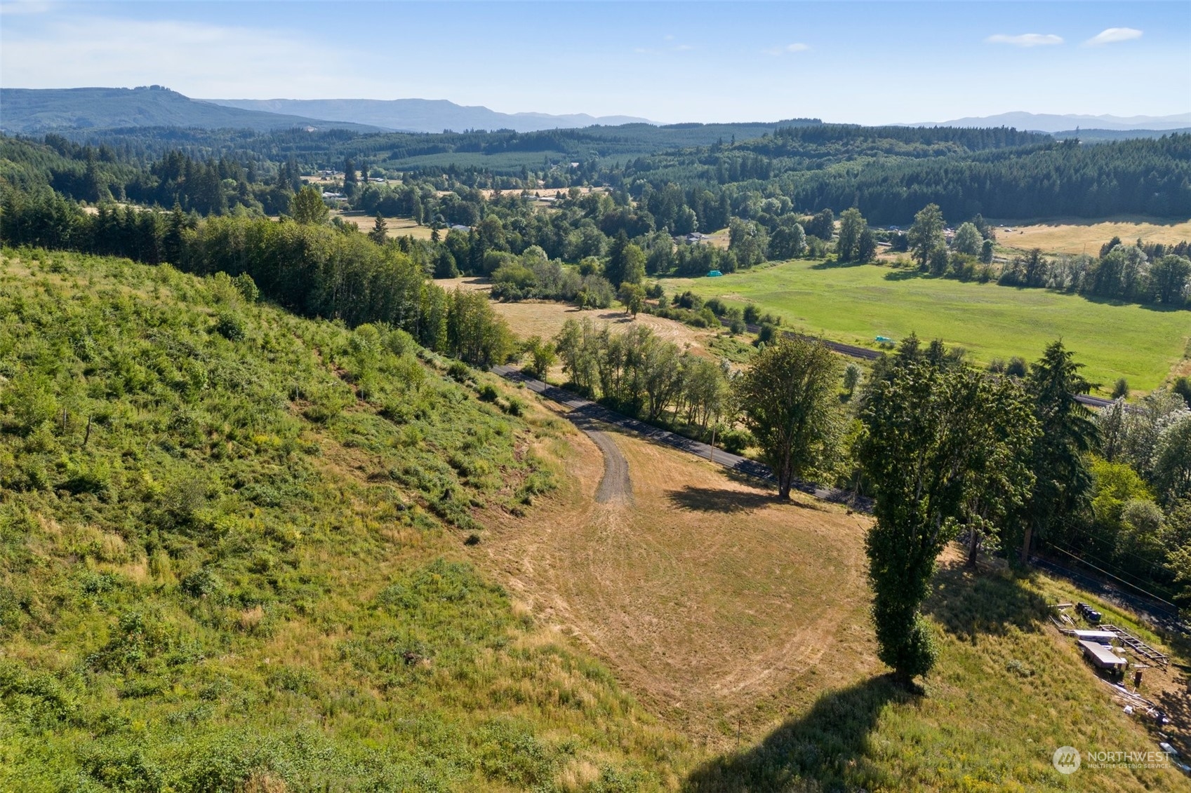 an aerial view of residential houses with outdoor space and trees