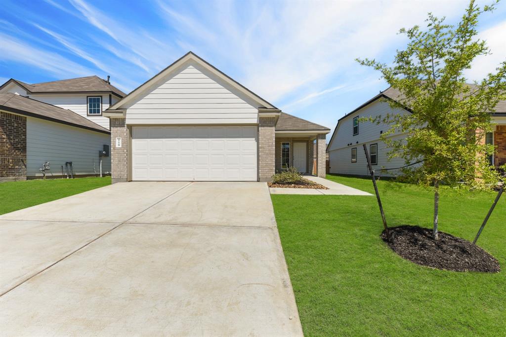 a front view of a house with a yard and garage