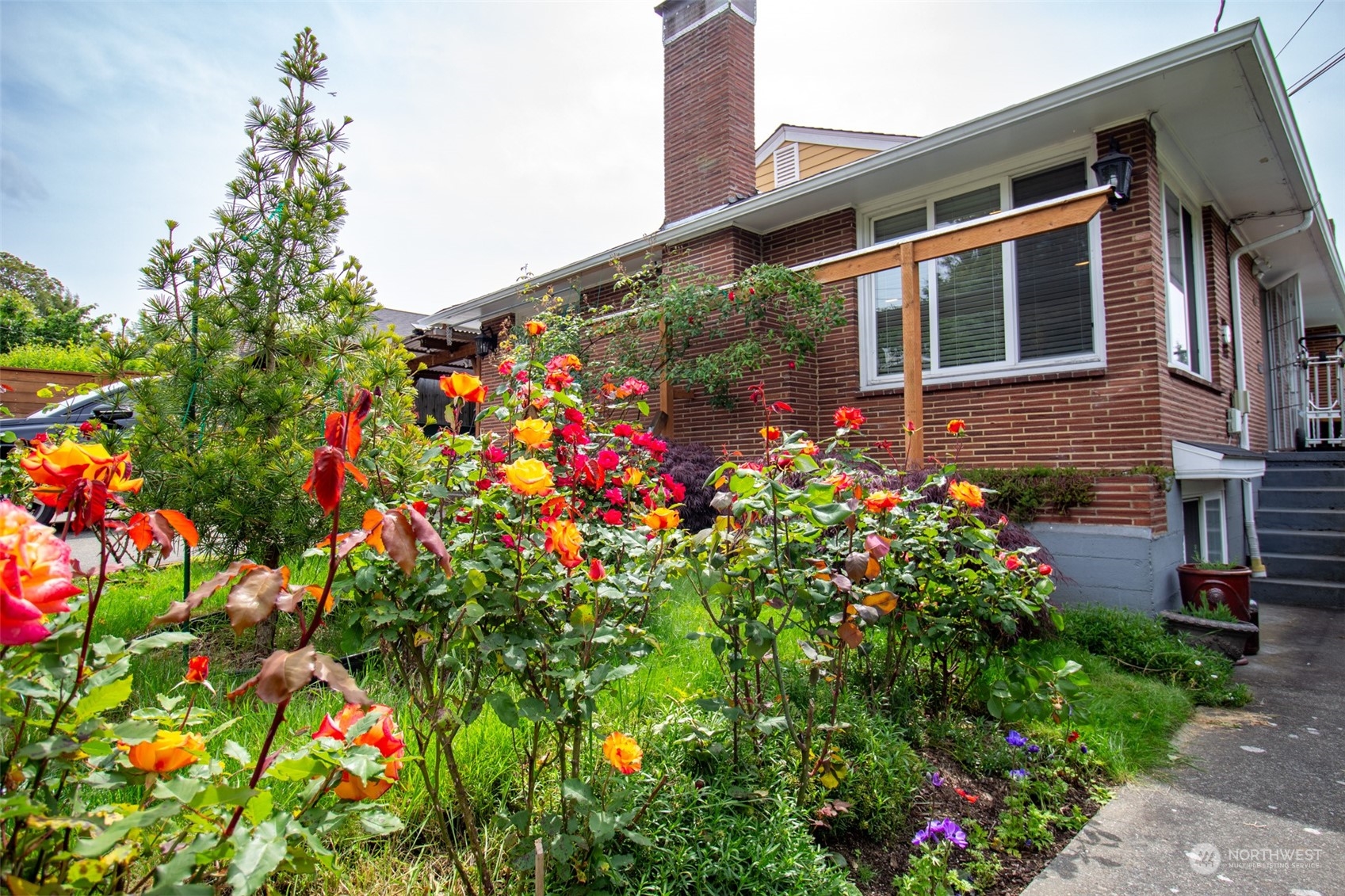 a front view of a house with a yard and flowers