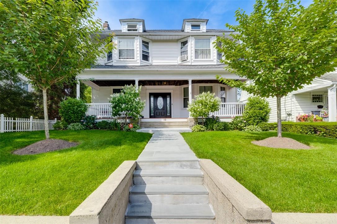 View of front of property with a front lawn and covered porch