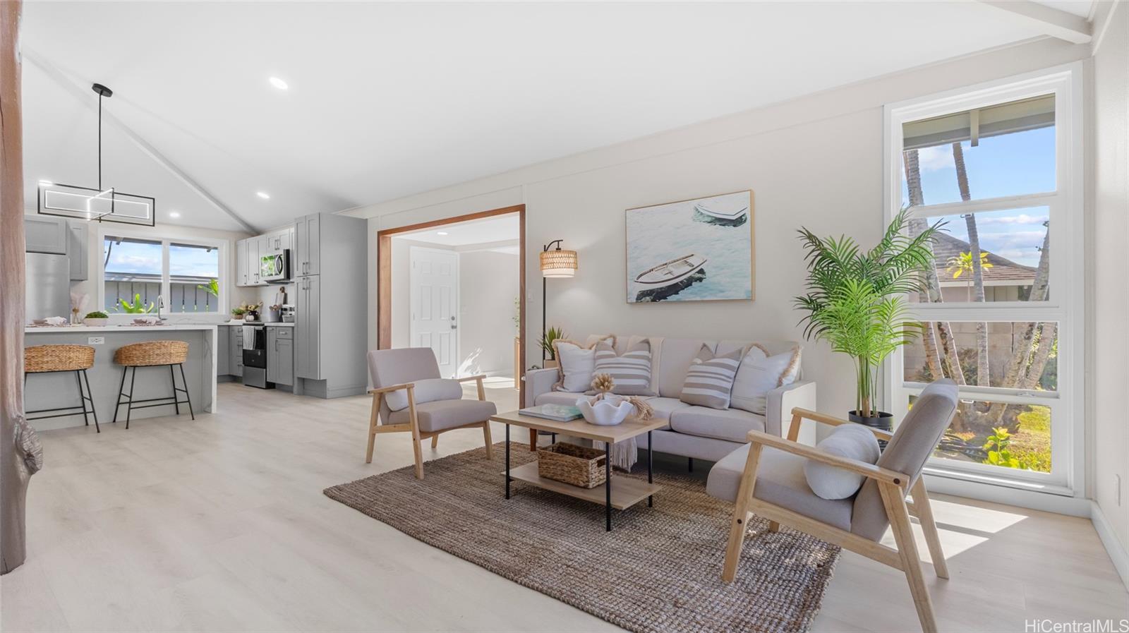 High ceilings, view of the living room, kitchen, and dining/flex room. White door leads to the backyard, laundry, carport.