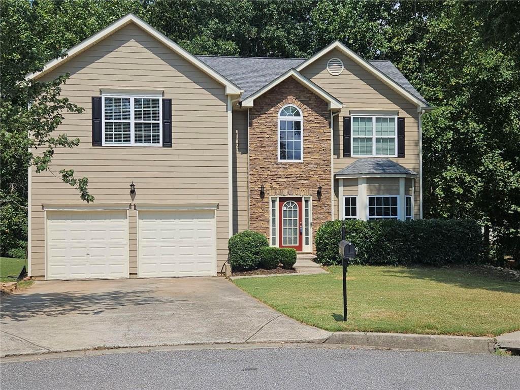 a front view of a house with a yard and garage