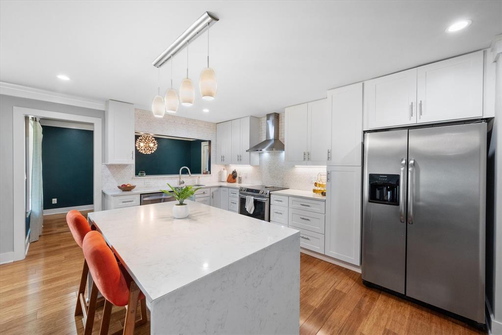 a large kitchen with a table chairs refrigerator and a window