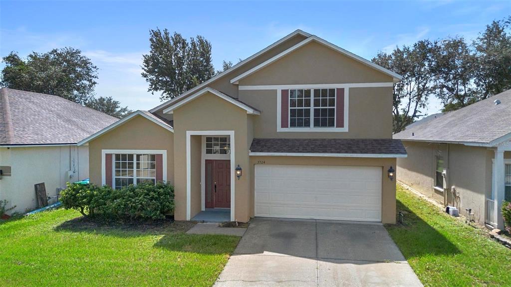 a front view of a house with a yard and garage