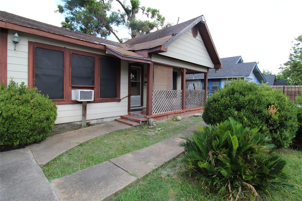 a view of a house with brick walls and a yard with plants