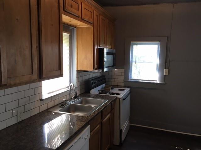 a kitchen that has a sink a stove and a window