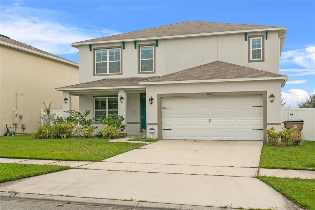 a front view of a house with a yard and garage