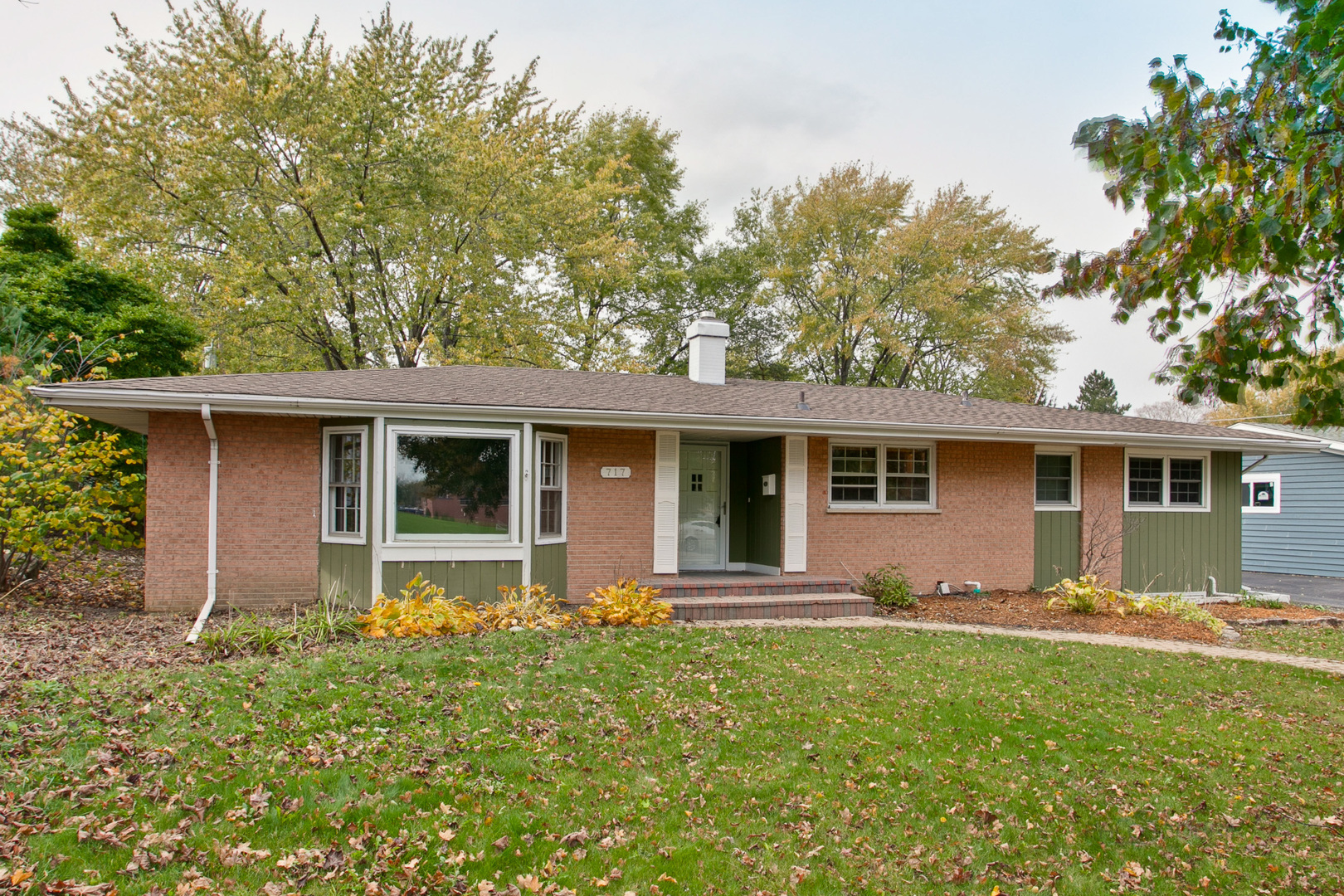 a front view of house with yard and trees around