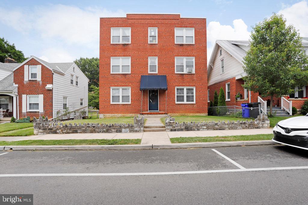 a front view of a residential apartment building with a yard