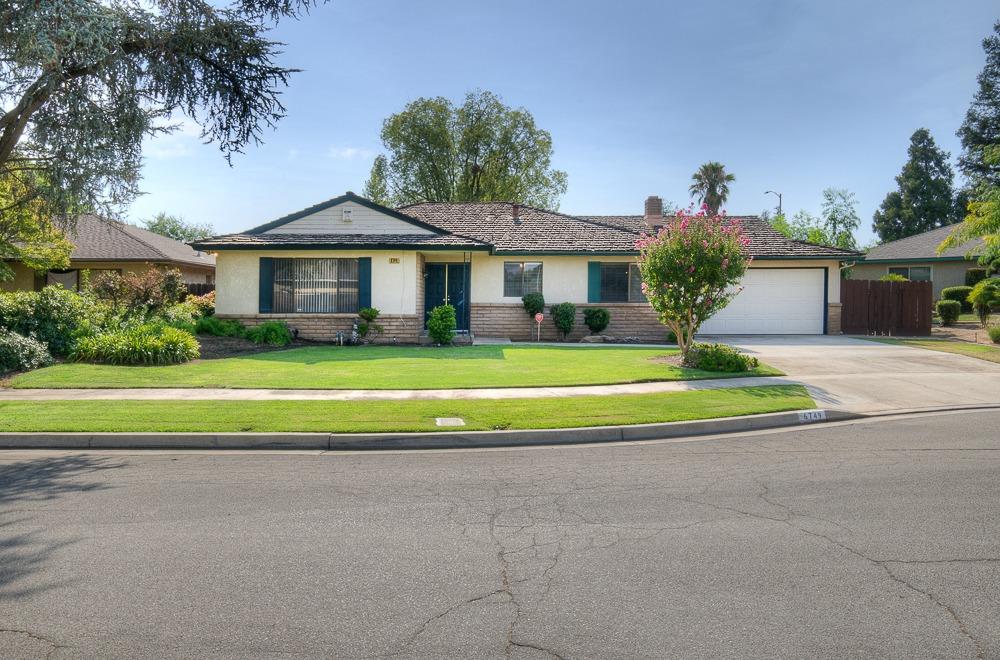 a front view of a house with a yard and potted plants