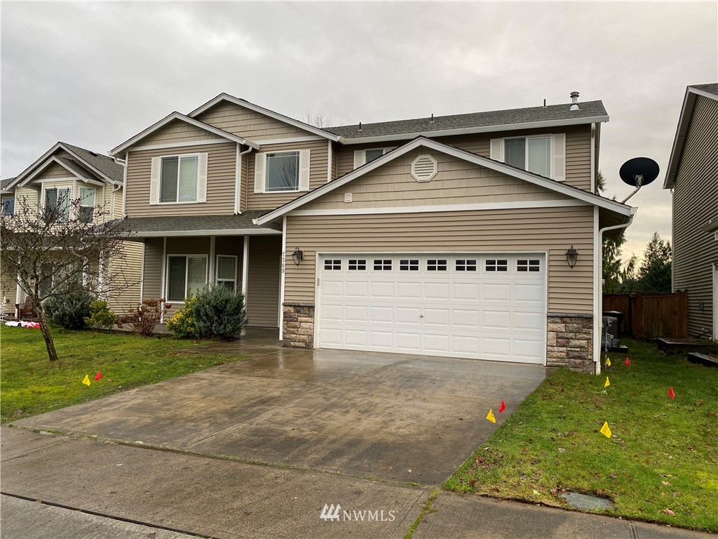 a front view of a house with a yard and garage