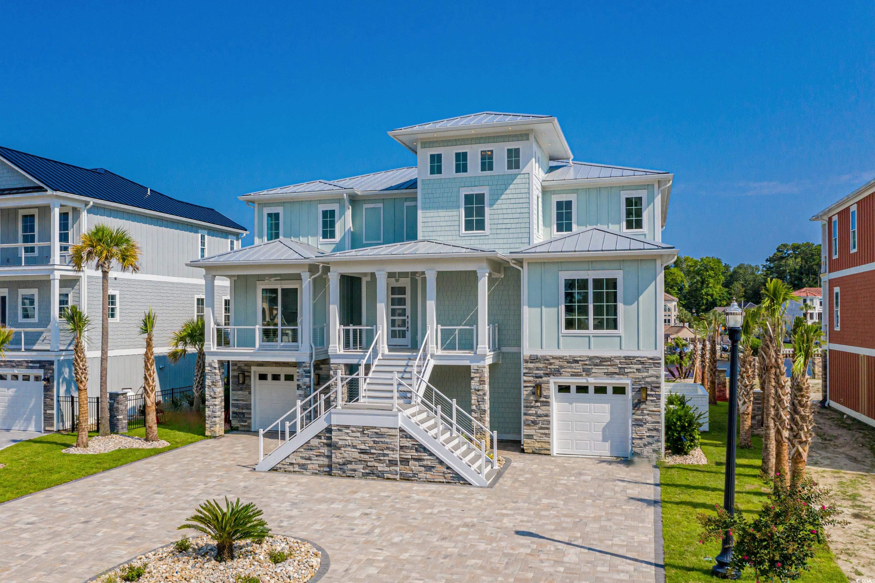 View of front of home featuring a garage and cover