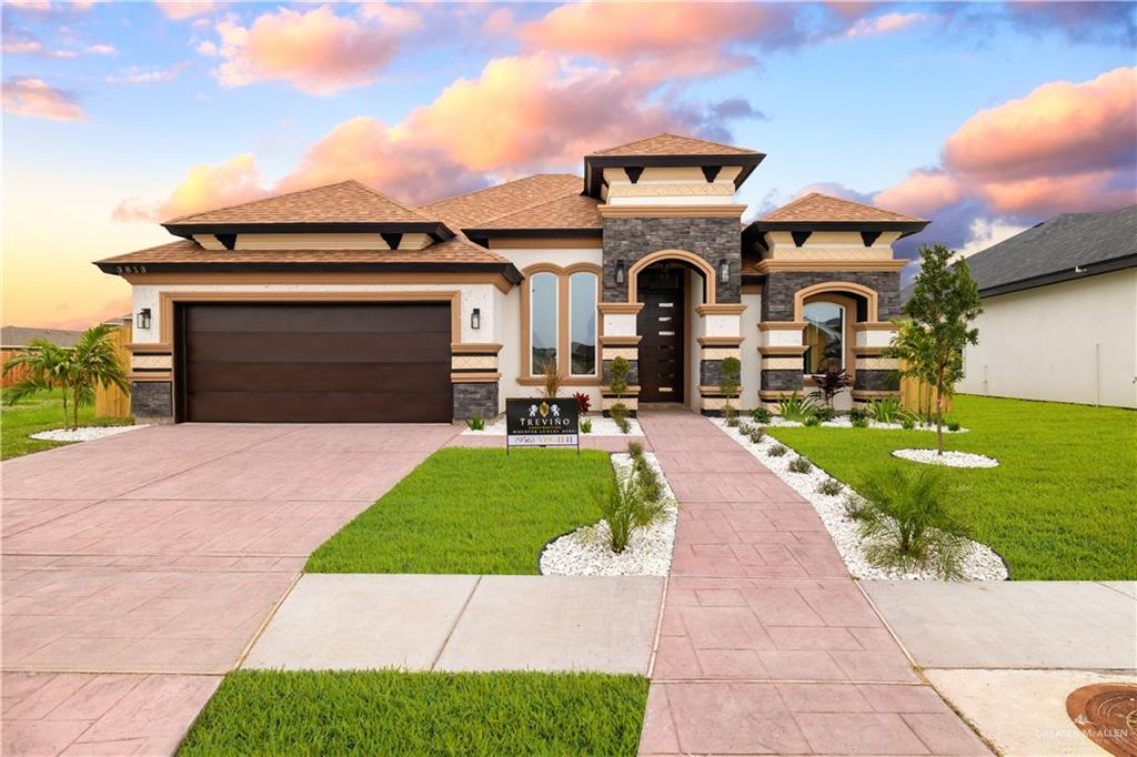 a front view of a house with a yard and trees