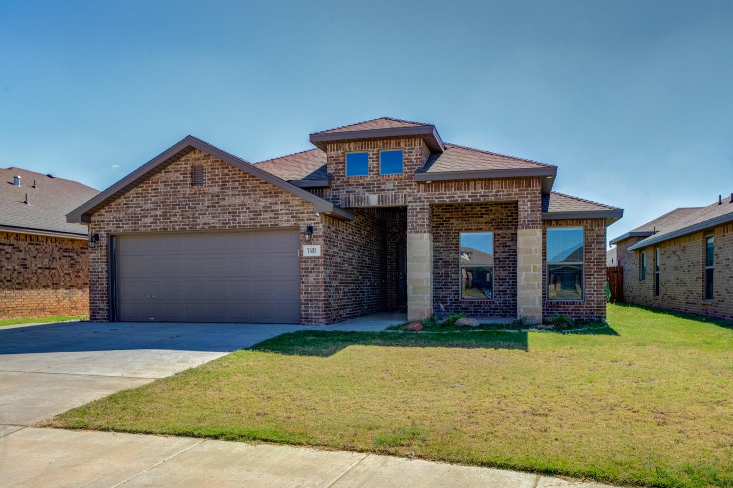 a front view of a house with a yard and garage