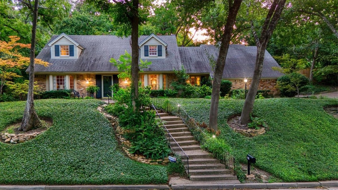 a front view of a house with a yard and green space