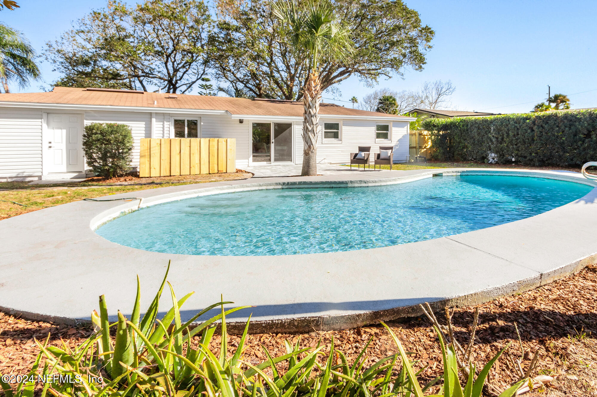 a view of a house with backyard and sitting area