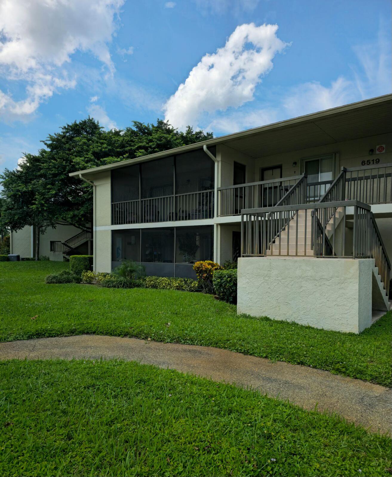 a view of a house with a yard and a large tree