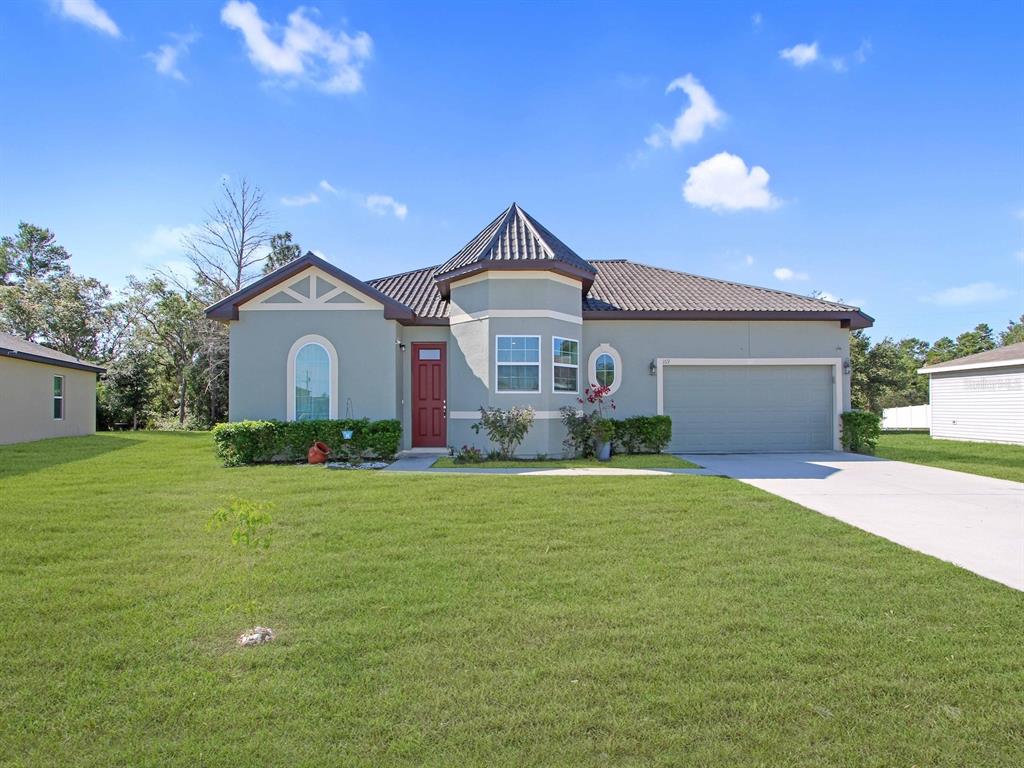 a front view of a house with a garden and yard