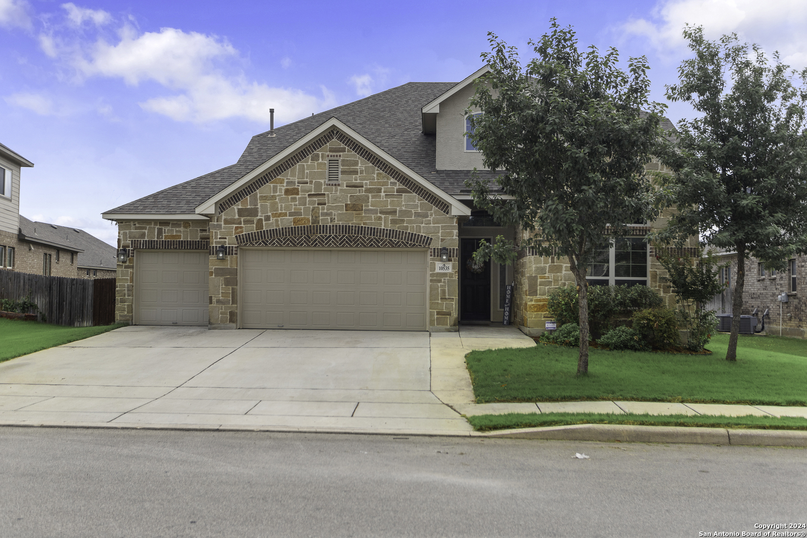 a front view of a house with a yard and garage