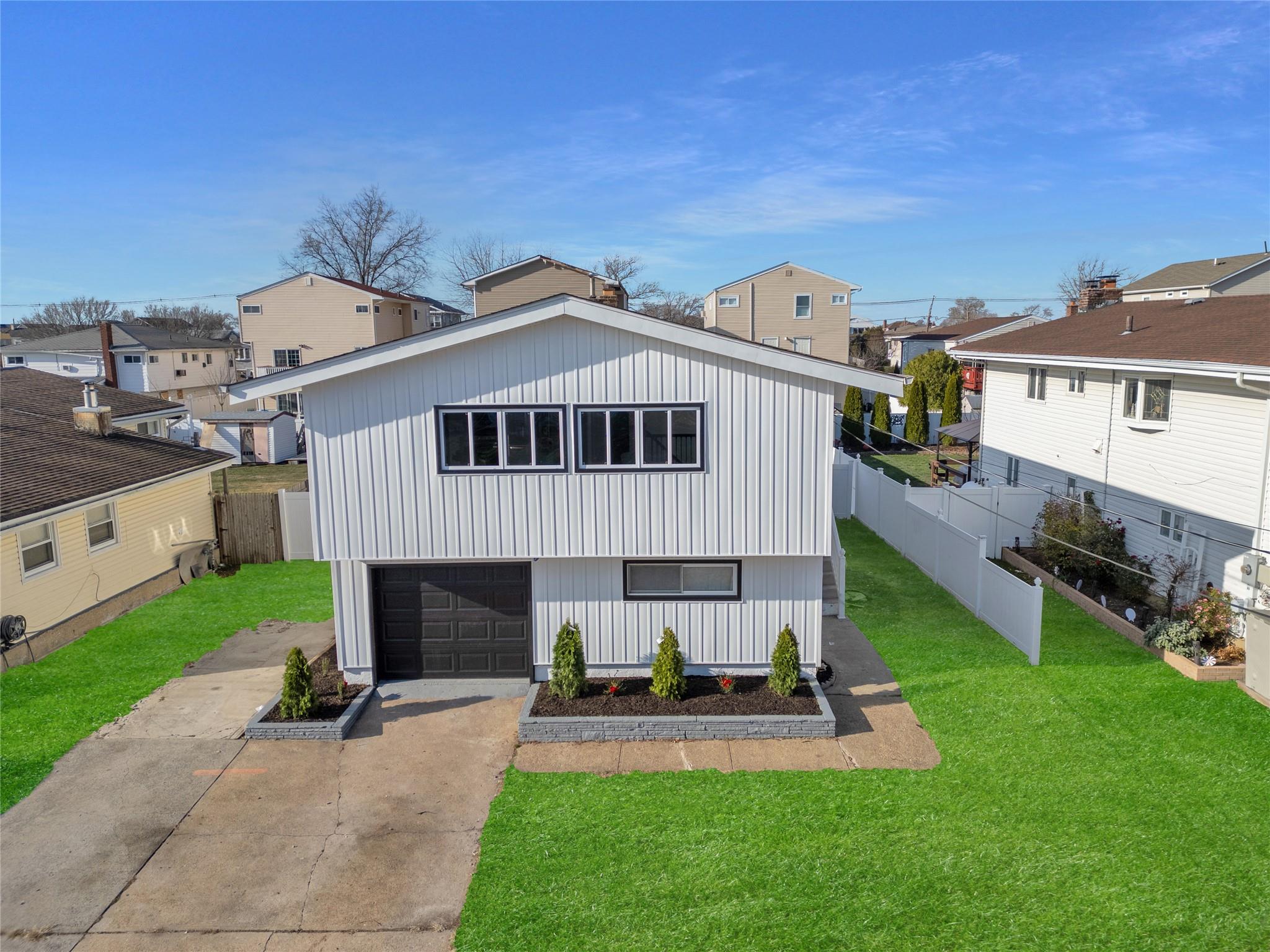 View of front of home featuring a front yard and a garage