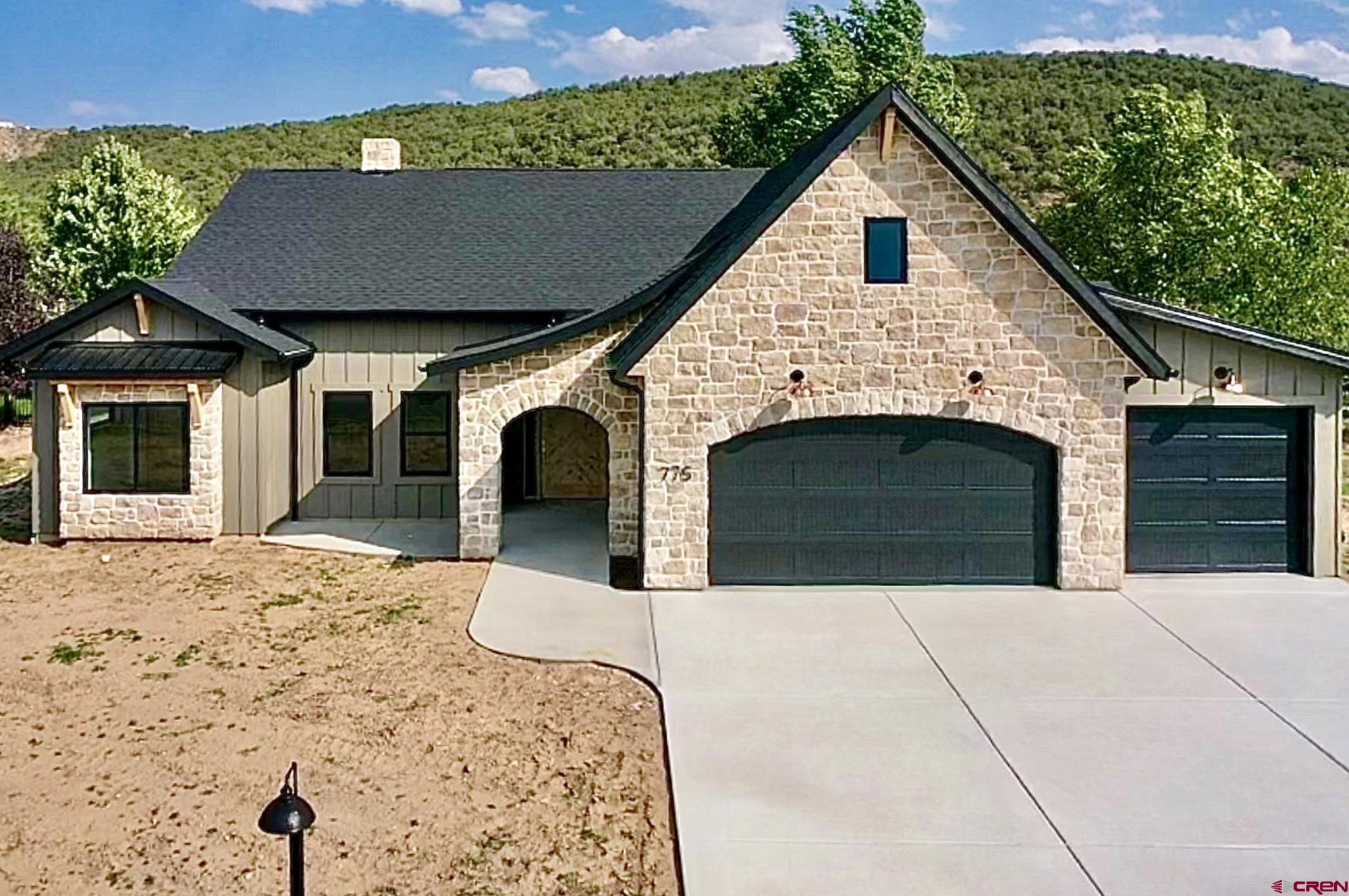 a view of house with yard and garage