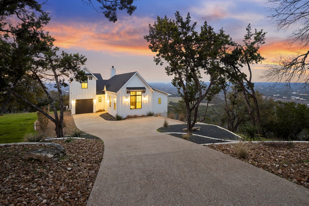 a front view of a house with a yard and tree s