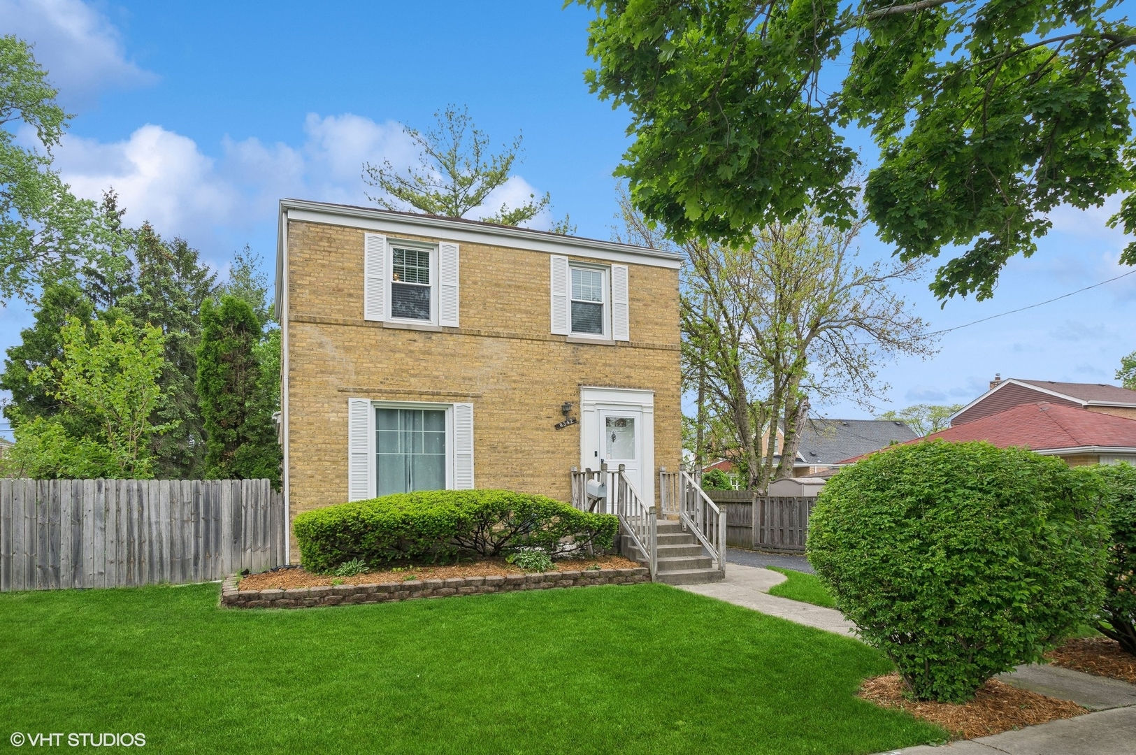 a front view of a house with a garden