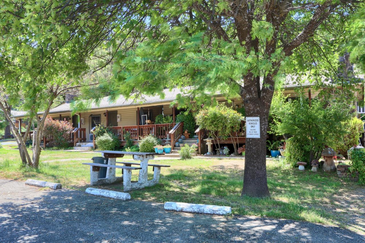 a front view of a house with garden and trees