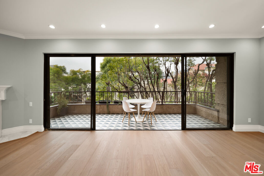 a view of an empty room with wooden floor and a floor to ceiling window