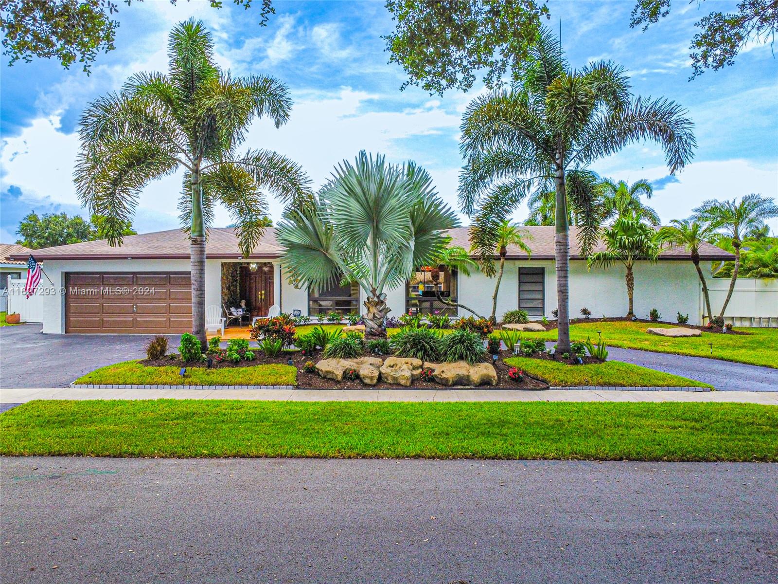 a front view of a house with a yard and potted plants