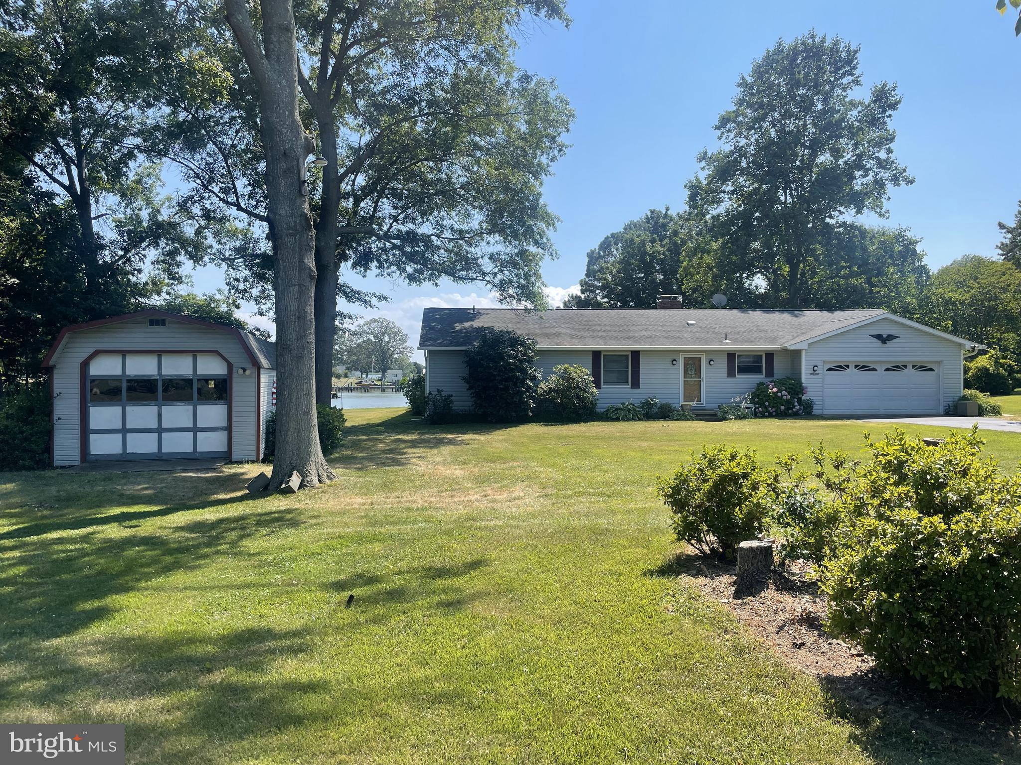 a front view of house with yard and trees in the background